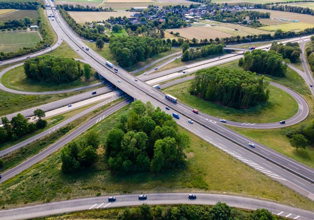 Top view of cars driving on round intersection in city. Aerial view of road in Germany